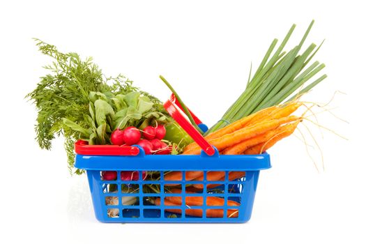 Shopping basket filled with healthy vegetables over white background