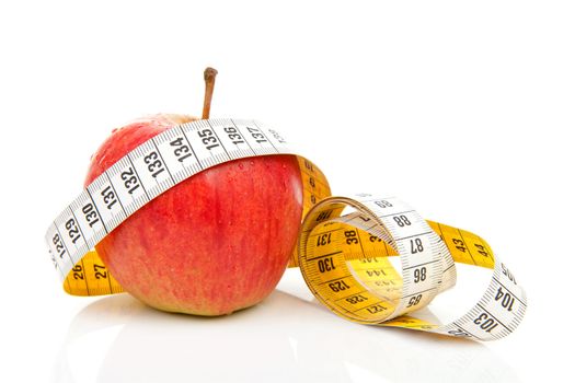 healthy diet; red apple with measure tape over white background