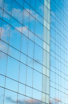 Office building and blue sky with clouds reflection