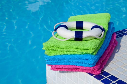 colorful towels and life buoy near the swim pool