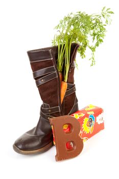 Shoe with carrot, chocolate letter and present over white background, typical Dutch tradition for Sinterklaas in december