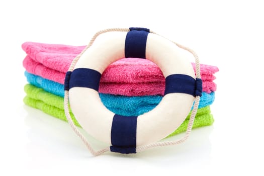 colorful towels and life buoy over white background
