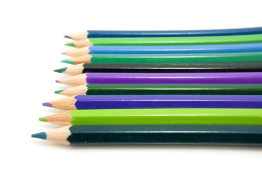 colored pencils in a row over white background