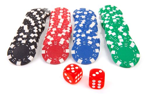 colorful casino poker chips and red dices over white background