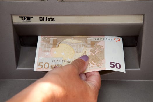 ATM Access : a womans hand withdraws money at cashpoints
