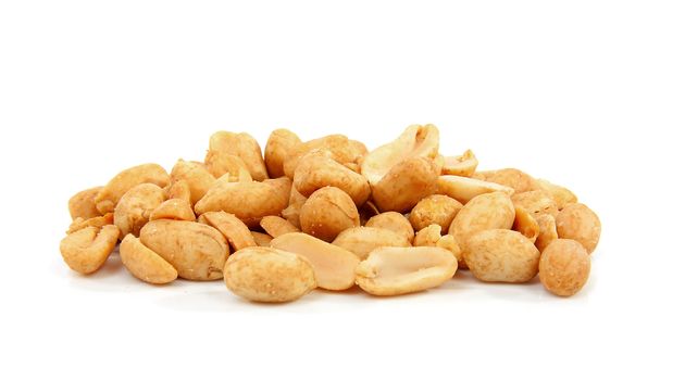 salted peanuts in closeup over white background