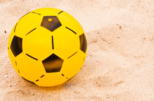 Yellow football at to the  beach.