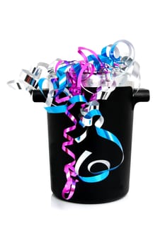 festive black champagne cooler with streamers over white background