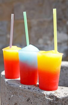 colorful slushy ice drinks in plastic cups