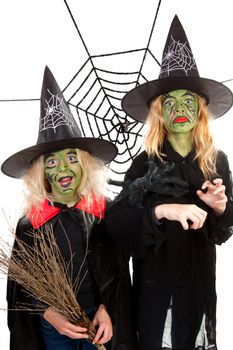 Scary green witches for Halloween with spiderweb over white background