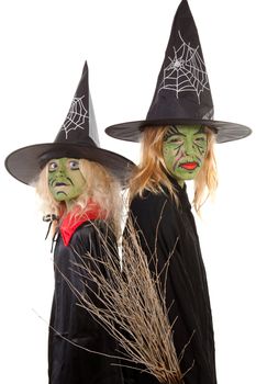 two green halloween witches in closeup over white background