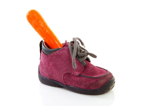 purple little children's shoe with carrot, traditional for Sinterklaas in the Netherlands over white backgorund