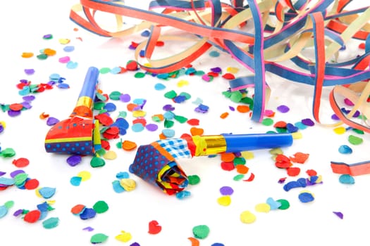 colorful party attributes with streamers, confetti and horns over white background