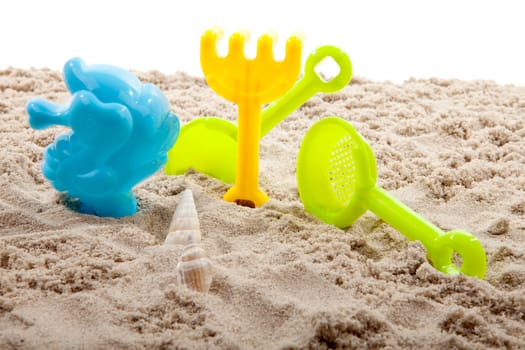 beach toys in sand over white background