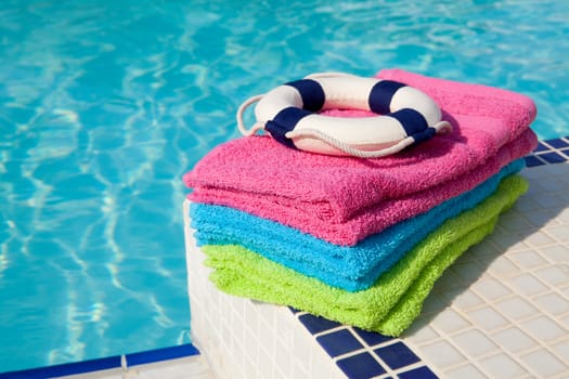 colorful towels and life buoy near the swim pool