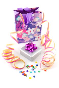 bag with gift and party streamer over white background