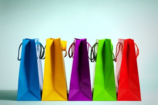 five colorful shopping bags in a row in fashion light