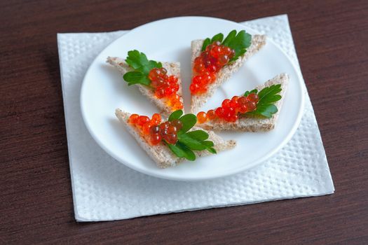 Sandwiches with red caviar and parsley