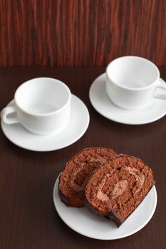 chocolate cake on a plate with a cup