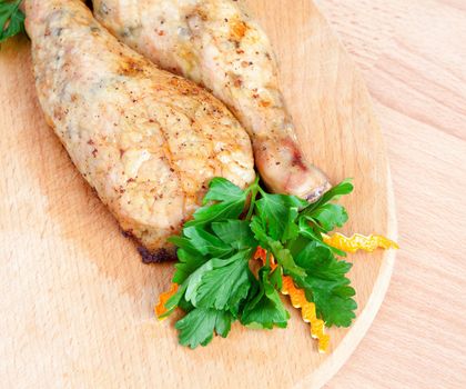 Fried chicken legs with parsley on the board