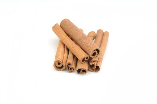 Cinnamon sticks in pile on white background