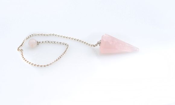 new age crystal pendulum accessory that is a pink rose quartz stone