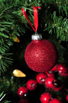 Red glitter holiday ornament and berries for Christmas