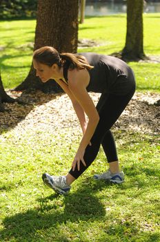 young woman stretching outdoors after run
