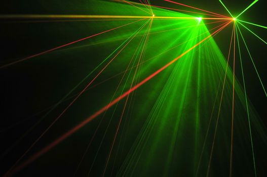 Colour lasers in smoke on a black background.