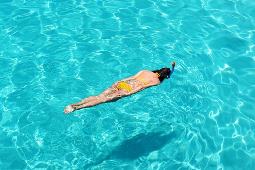 Woman snorkeling in crystal clear turquoise water at tropical beach