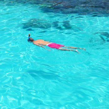 Man snorkeling in crystal clear turquoise water at tropical beach