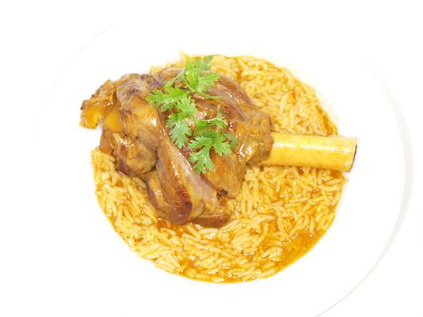 Lamb shank in juicy yellow rice, on white plate towards white