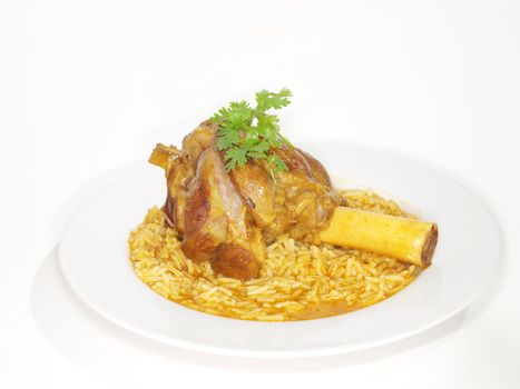 Lamb shank in juicy yellow rice, on white plate towards white