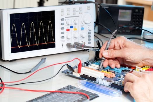 Tech tests electronic equipment in service centre