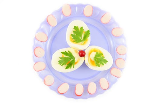 Cooked boiled eggs with sauce, decorated with parsley,  cranberry and crab sticks