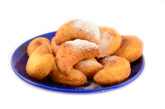 Sweet cottage cheese donuts in powder on a dark blue plate