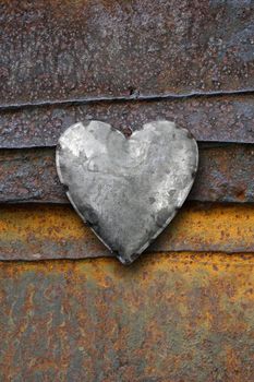 Photo of metal heart on a rusting iron background.