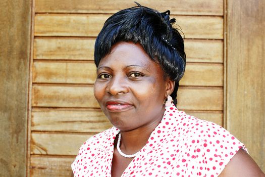 Candid portrait of a beautiful mature black African woman, dressed up for work at the office.