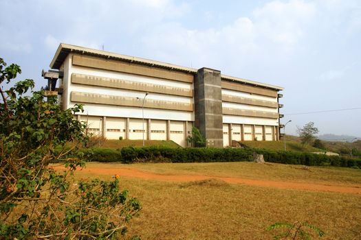 Large concrete building, can be school, business or others, in tropical country with red earth such as central Africa.