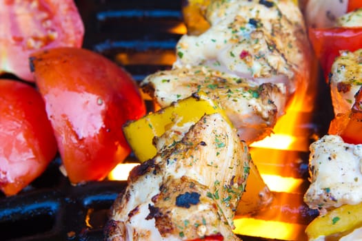 chicken and pepper kebabs slowly cooking on the barbecue