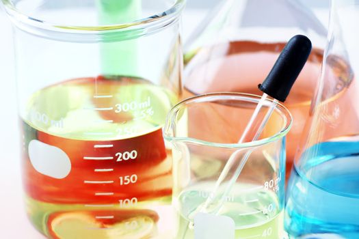 Science, research or chemistry background: interesting macro shot of laboratory glassware with colorful chemicals or liquids, stacked focus.