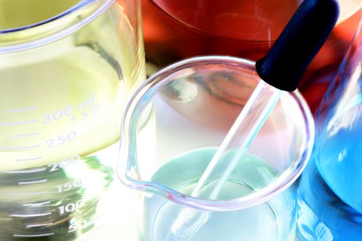 Science, research or chemistry background: interesting macro shot of laboratory glassware with colorful chemicals or liquids, stacked focus.