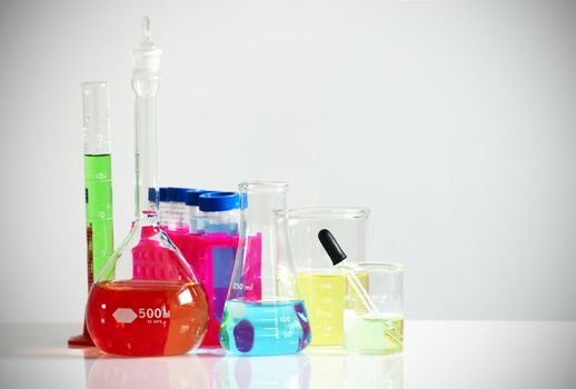 Science, research or chemistry concept: set of different laboratory glassware, flask, beaker and others filled with colorful chemicals or liquids.