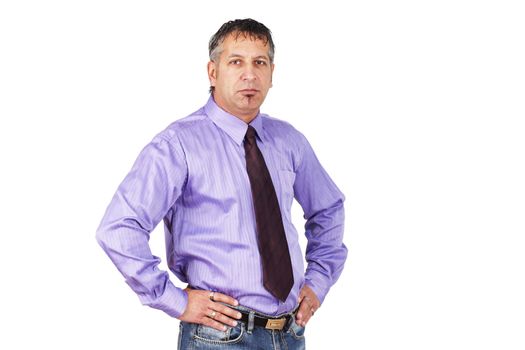 The guy at the office, disgruntled employee or grumpy boss, middle aged man with hands on hips looking mad or unhappy in shirt and tie with jeans.