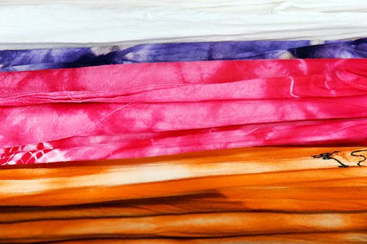 Great texture background made with tie dye cotton fabrics in bright pink, orange and purple.