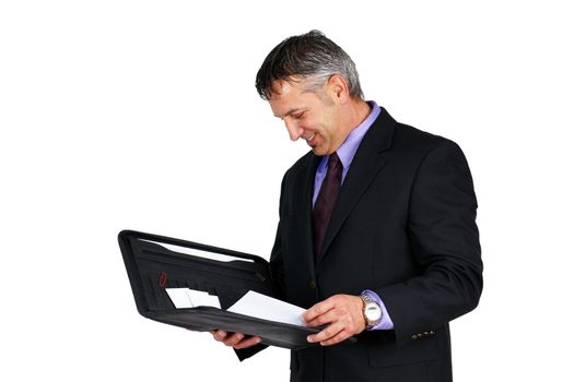 Man in suit and tie, holding paperwork looking at it and smiling, can be boss or management employee.