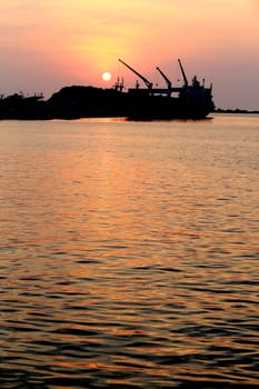 Cargo ship in the harbor at sunset