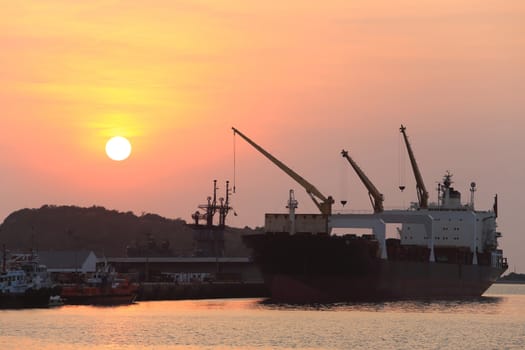 Cargo ship in the harbor at sunset