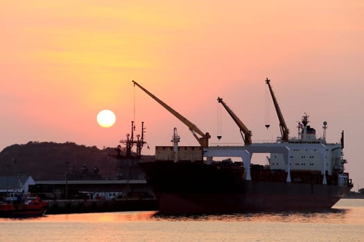 Cargo ship in the harbor at sunset