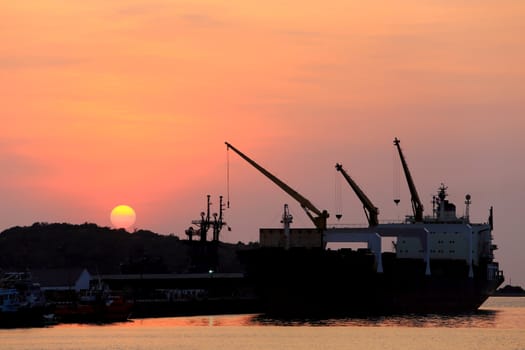 Cargo ship in the harbor at sunset